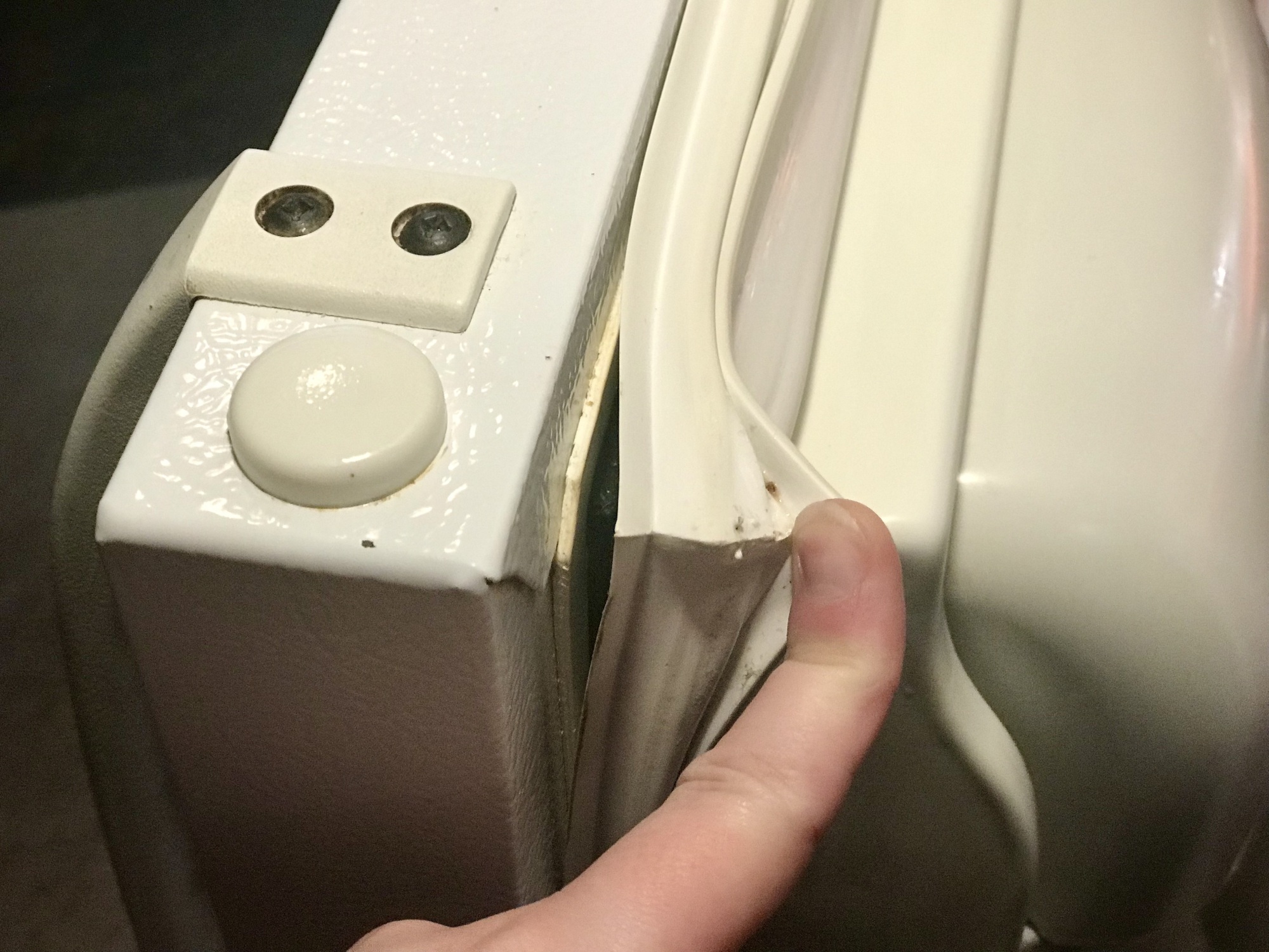 finger pushing white refrigerator seal out of groove